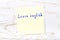 Yellow sticky note with handwritten text learn english