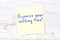 Yellow sticky note with handwritten text organize your working time