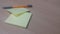 Yellow sticky note paper with pen placed on a wooden table