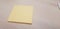 Yellow sticky note without text to be filled on a light wood background