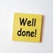 Yellow sticky note with the word well done