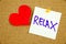 A yellow sticky note writing, caption, inscription Motivational concept - relax - handwriting on a yellow sticky note