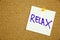A yellow sticky note writing, caption, inscription Motivational concept - relax - handwriting on a yellow sticky note