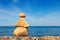 Yellow stones balance on a background of blue sky and sea