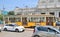 Yellow streetcar tram in traffic at the stop in front of the Milan train station