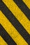 Yellow striped road markings on black asphalt.