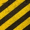 Yellow striped road markings on black asphalt.