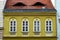 yellow stucco residential apartment building elevation closeup. wood windows and roof dormers