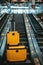 Yellow suitcase set on an airport escalator.