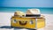 Yellow suitcase with two straw hats on the sand near the sea