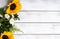 Yellow sunflower arrangement on white wood background with copy space