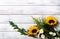 Yellow sunflower arrangement on white wood background with copy space