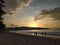 Yellow sunset peek behind hills view from sandy beach