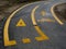 Yellow surface traffic signs of yield and bicycle lane on asphalt