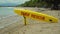 Yellow surfboard on beach with red text surf rescue emergency on a beach