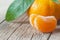 Yellow sweet peeled and whole mandarin clementine tangerine on wooden rustic vintage table with leaf. Tangerines backgrou