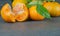 Yellow sweet peeled and whole mandarin clementine tangerine on wooden rustic vintage table with leaf. Tangerines backgrou