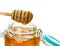 Yellow sweet sticky honey flows from a wooden spoon for honey into a glass jar with a lid space for text