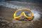 Yellow swimming mask on the sandy beach