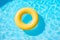 Yellow swimming pool ring float in blue water.