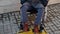 yellow symbol of disability on tiled street floor and wheelchair-bound man