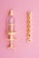 Yellow syringe for applying glaze on confectionery products on pink