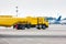 Yellow tank truck aircraft refueler at the airport apron