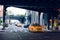 Yellow taxi cab traveling under bridge in New York