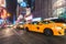 Yellow taxi cabs and glowing electric signs near Times Square