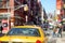 Yellow taxi cabs and people rushing on busy streets of downtown Manhattan.