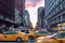 Yellow taxi cabs speeding down Broadway during rush hour in New York City