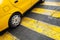 Yellow taxi car stands on pedestrian crossing
