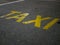 Yellow taxi inscription on the pavement. A place for parking and waiting for a taxi driver