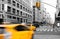 Yellow taxis driving in black and white street scene on Fifth Avenue in Manhattan New York City