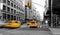 Yellow taxis driving down the street isolated on black and white view of New York City