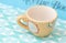 Yellow teacup on blue retro background. Measuring cup.