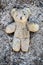Yellow teddy bear lies wounded in a pile of ash