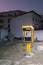 A yellow telephone booth surrounded by buildings  Muscat  Oman