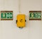 A yellow telephone box on the wall of a cruise ship.