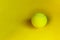 Yellow tennis ball over yellow background. Abstract sport background.