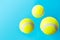 Yellow tennis balls floating levitating in air on light blue background active lifestyle competition victory concentration concept