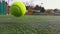 Yellow tennis balls in super slow motion 1000 fps on a clay green court next to the white line with copy space, soft