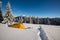 Yellow tent and snowshoes are standing at alpine meadow