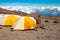 Yellow tents in the base camp above the clouds