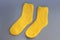 Yellow terry socks on a gray background.