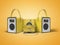 Yellow three portable speaker for listening to music in leather binding 3d render on orange background with shadow