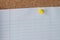 Yellow Thumb Tack Holding Paper on Cork Board