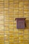 Yellow tiles wall with red rusty postbox