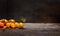 Yellow tomatoes branch on rustic table over dark wooden background, healthy food