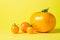 Yellow tomatoes on a yellow background. Ripe juicy tomatoes. Tomato variety.